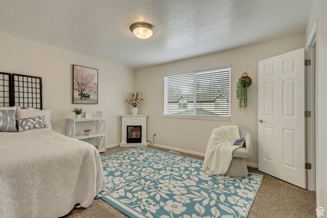 Carpeted bedroom featuring baseboards and a glass covered fireplace | Image 11