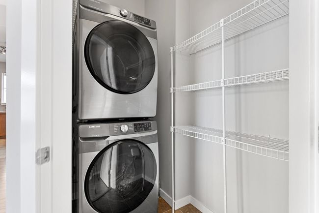 Laundry - storage area with deluxe stainless steel stacked washing machine and dryer and shelving . New W/D Oct 2021 | Image 35