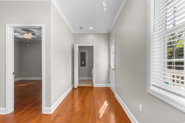 Hallway with crown molding, light wood-style floors, baseboards, recessed lighting, and electric panel | Image 19