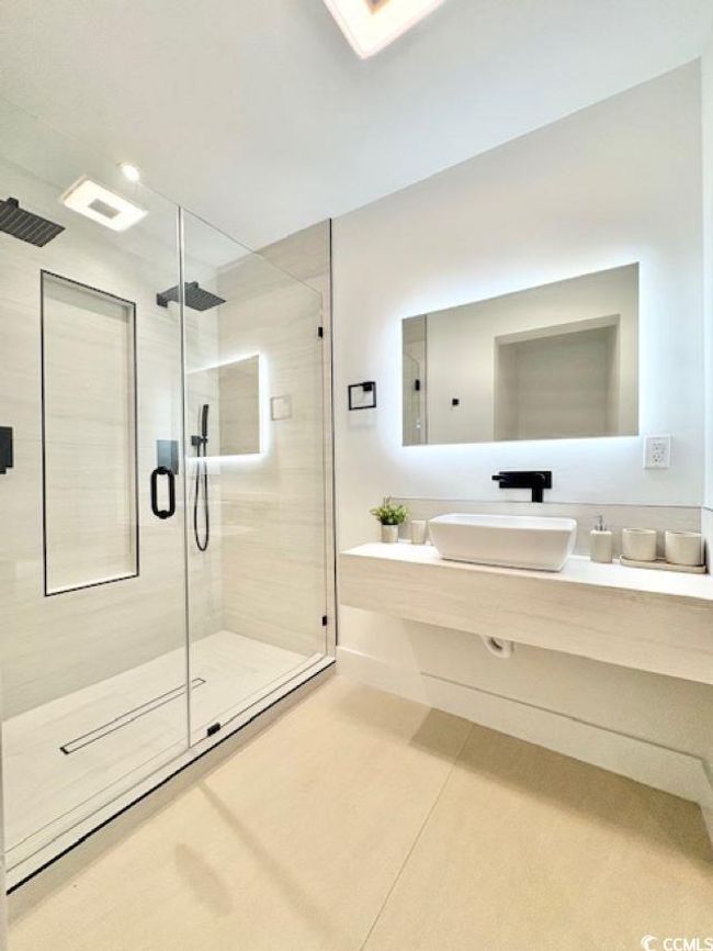 Full bathroom with a stall shower, vanity, and tile patterned flooring | Image 29