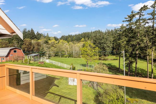 Wooden deck with a wooded view and an outdoor structure | Image 8