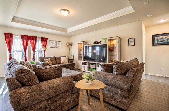 Living room featuring a raised ceiling, crown molding, and wood finished floors | Image 13