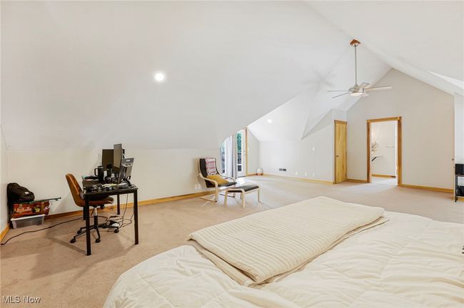 Bedroom featuring vaulted ceiling, light colored carpet, a desk, and a ceiling fan | Image 33