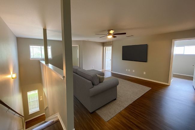 Living area featuring dark wood-style flooring, ceiling fan, and plenty of natural light | Image 18