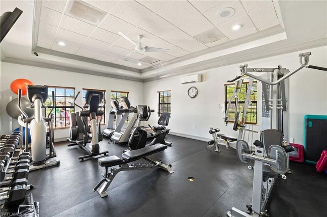 Gym with a raised ceiling, crown molding, and a wall mounted air conditioner | Image 10