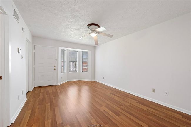 Spare room with light wood-style flooring, a textured ceiling, and a ceiling fan | Image 7