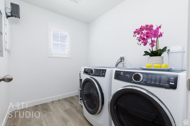 Clothes washing area with light wood finished floors, independent washer and dryer, laundry area, and baseboards | Image 35