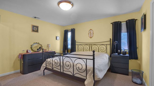 Bedroom featuring carpet floors, baseboards, and visible vents | Image 8
