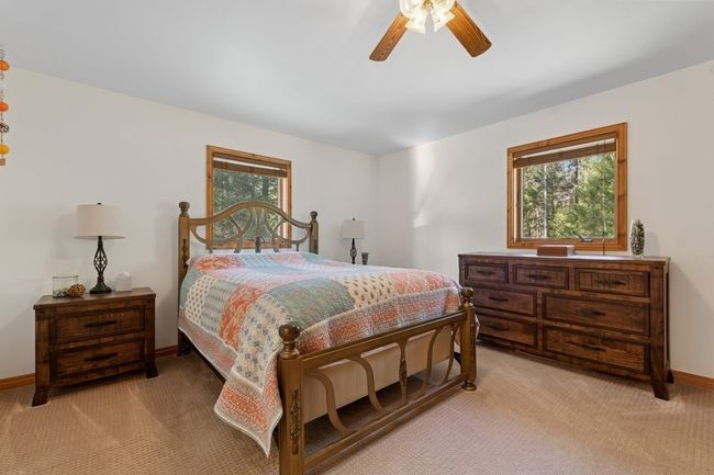 Bedroom with spacious area, ceiling fan, and beautiful views of nature. Located on upper level. | Image 62