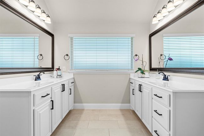Full bathroom with lofted ceiling, two vanities, plenty of natural light, and tile patterned flooring | Image 23