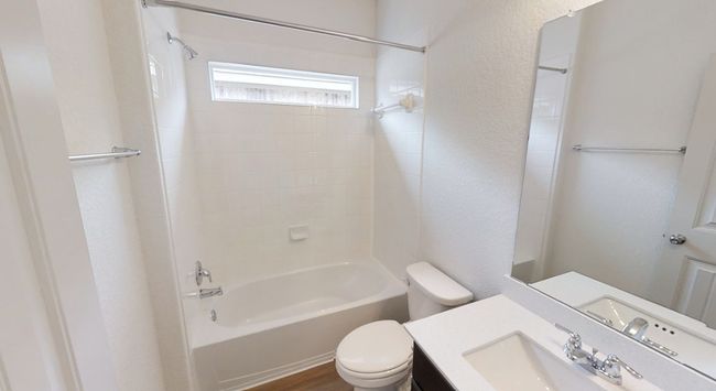 Bathroom featuring a textured wall, shower / bath combination, and vanity | Image 11