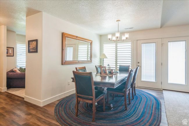 Dining room with a chandelier, a textured ceiling, baseboards, and dark wood-style flooring | Image 10