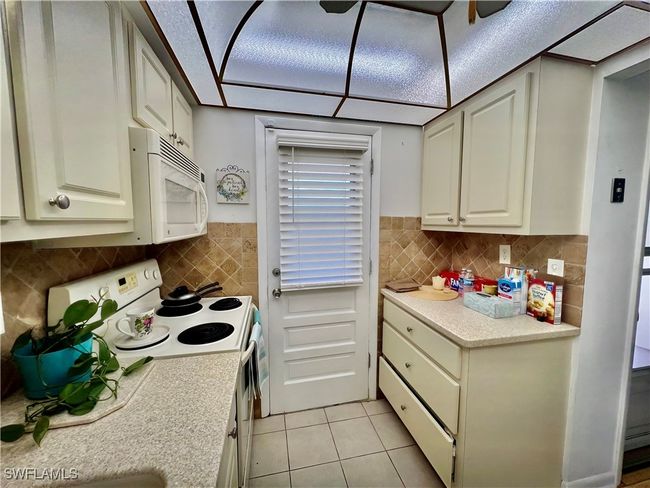 Kitchen with solid surface countertops and stone tile backsplash. | Image 5