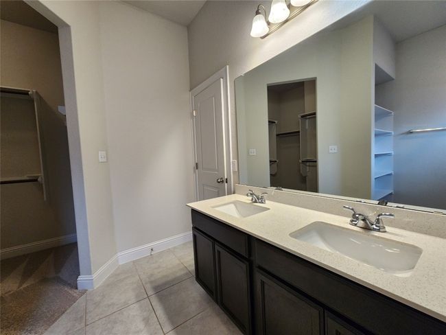 Bathroom with a spacious closet, double vanity, and tile patterned flooring | Image 16