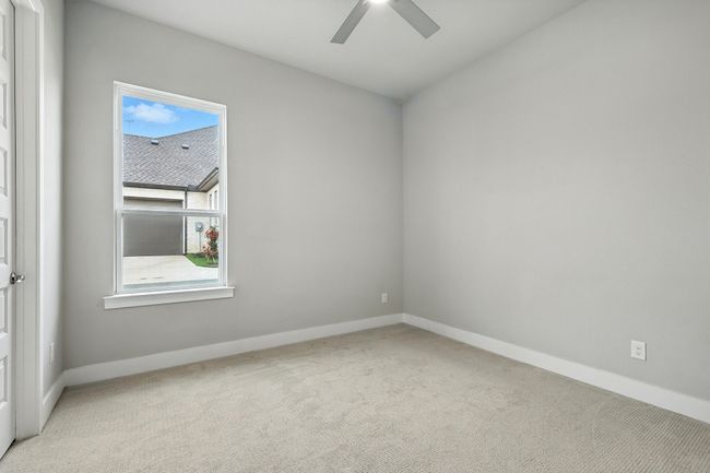 Carpeted empty room with a ceiling fan and baseboards | Image 25