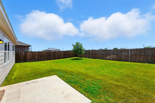 Fenced backyard with a patio area | Image 19