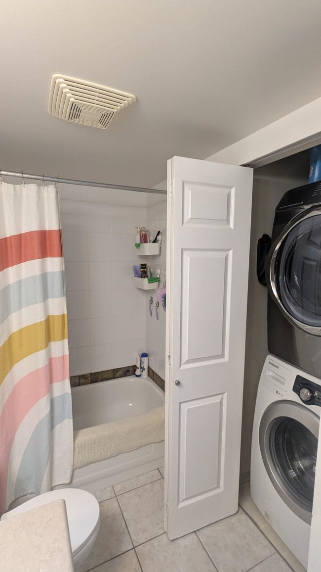 Washroom featuring stacked washer / dryer, light tile patterned flooring, visible vents, and laundry area | Image 19