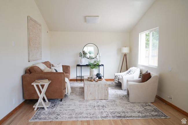 Living area with lofted ceiling and wood finished floors | Image 13