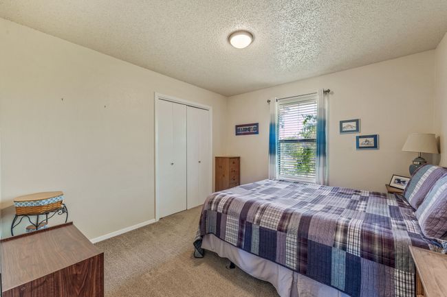 Carpeted bedroom with a closet and a textured ceiling | Image 17