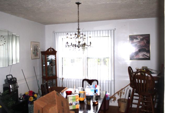 Dining room featuring a chandelier and a textured ceiling | Image 13
