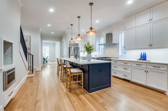Kitchen with crown molding, a sink, tasteful backsplash, appliances with stainless steel finishes, and wall chimney range hood | Image 10