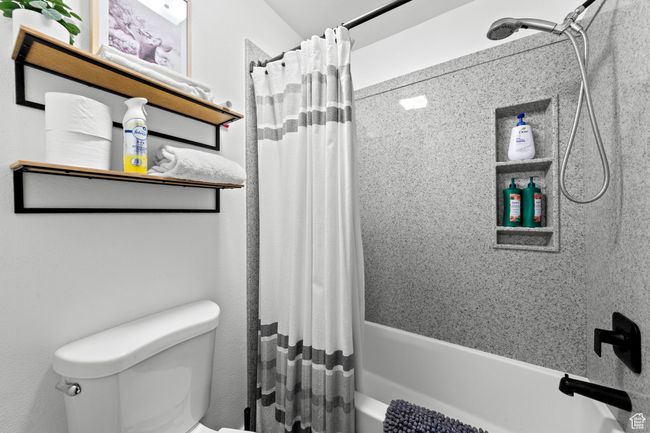 Full bathroom featuring shower / bathtub combination with curtain and toilet | Image 13