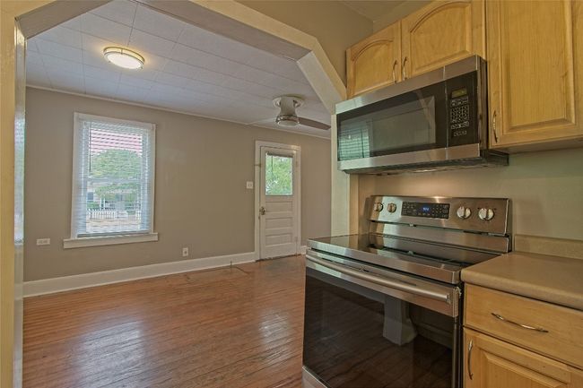 Kitchen featuring appliances with stainless steel finishes, hardwood / wood-style floors, a ceiling fan, light countertops, and light brown cabinetry | Image 18