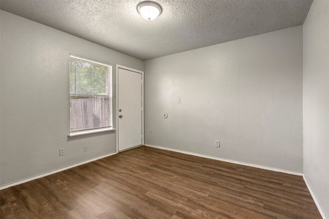 Unfurnished room with wood finished floors, baseboards, and a textured ceiling | Image 23