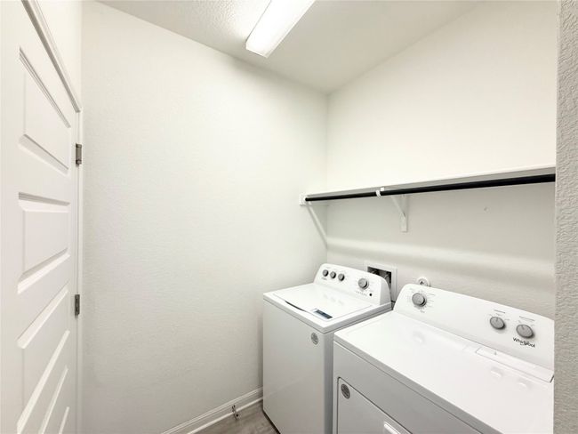 Laundry area featuring separate washer and dryer, baseboards, and wood finished floors | Image 22