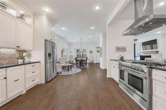 View looking towards breakfast area. Secondary stairs were removed to allow for additional width to the kitchen. All kitchen cabinets are completely custom built with recessed lighting for incredible ambiance. | Image 7