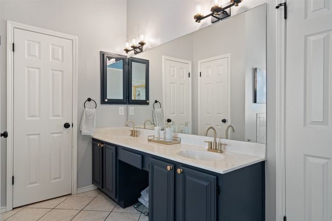 Full bathroom featuring tile patterned floors, a notable chandelier, double vanity, and a sink | Image 26
