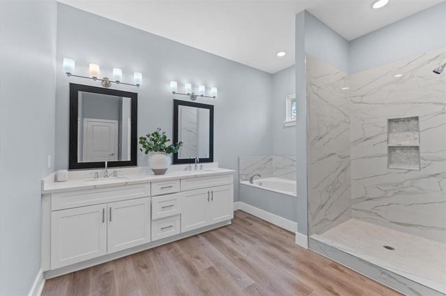 Spa-like bathroom with double sinks, soaking tub, separate shower, and walk-in closet. | Image 20