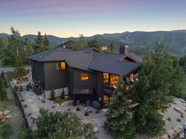 Rear view of house featuring a mountain view, roof with shingles, and stone siding | Image 86