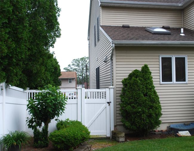 View of property exterior with a gate and a shingled roof | Image 43