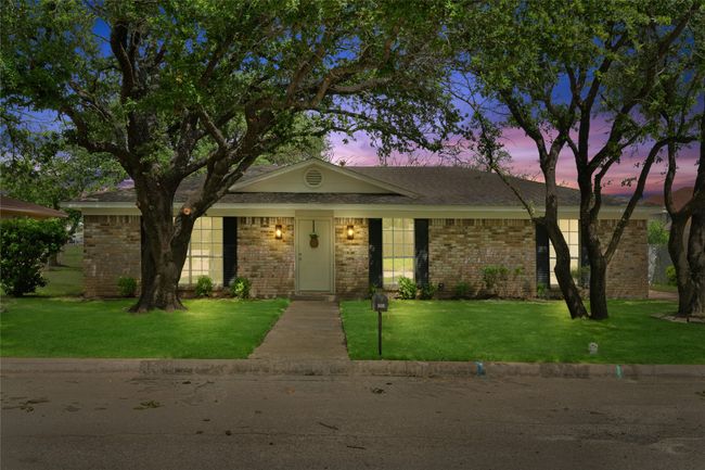 View of front of property featuring brick siding, a front yard, and a shingled roof | Image 33