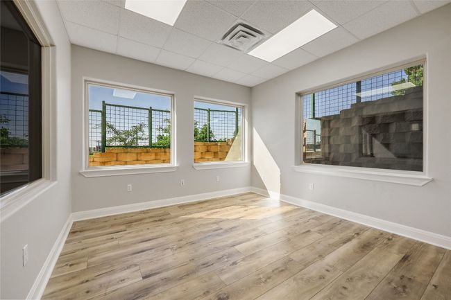 Spare room featuring baseboards, wood finished floors, visible vents, and a paneled ceiling | Image 34