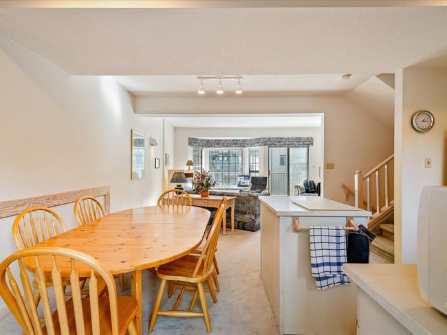 Dining space with light carpet and stairs | Image 10