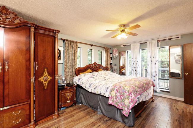 Bedroom featuring access to outside, a textured ceiling, wood finished floors, and ceiling fan | Image 17