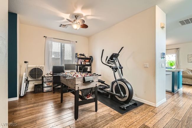 Office area featuring visible vents, a ceiling fan, and hardwood / wood-style flooring | Image 12