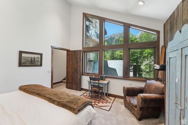 Carpeted bedroom with baseboards and a towering ceiling | Image 23
