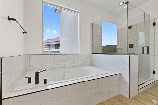 Bathroom with a stall shower, wood finished floors, and a garden tub | Image 12