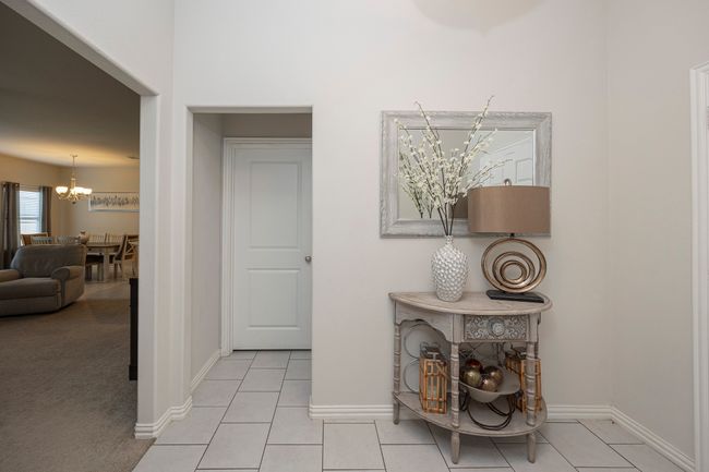 Hallway featuring a chandelier and light tile patterned floors | Image 25