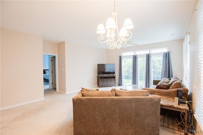 Living room with baseboards, light colored carpet, and an inviting chandelier | Image 5