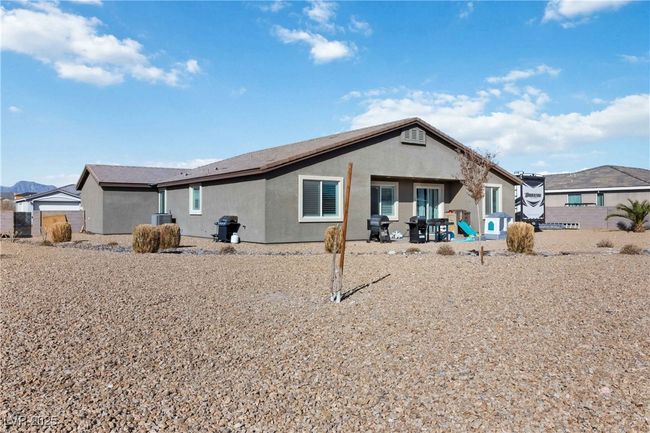 Back of property featuring central air condition unit, a patio area, and stucco siding | Image 41
