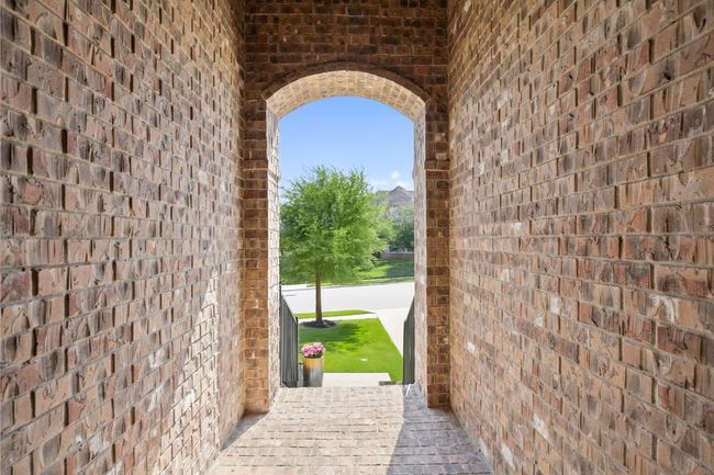 Inviting covered porch with a timeless brick entry adds character and curb appeal. | Image 4