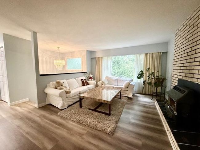 Living room featuring a chandelier, wood finished floors, and baseboards | Image 13