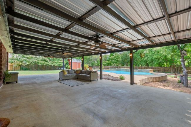Fenced backyard with a ceiling fan, a patio area, and outdoor lounge area | Image 32