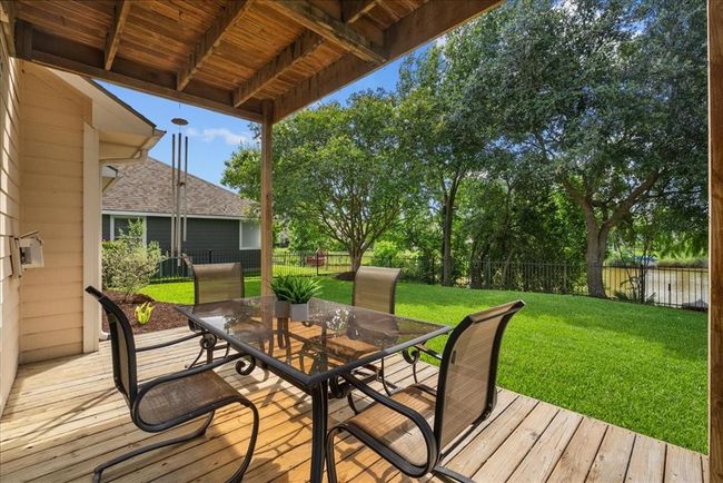 This covered patio area offers ample room for entertaining and watching beautiful sunsets on Kirby Lake. | Image 36