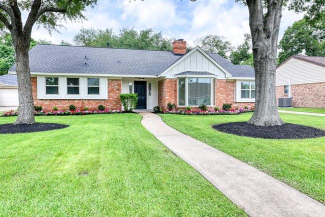 Mature trees and colorful landscaping create an idyllic front space. | Image 4