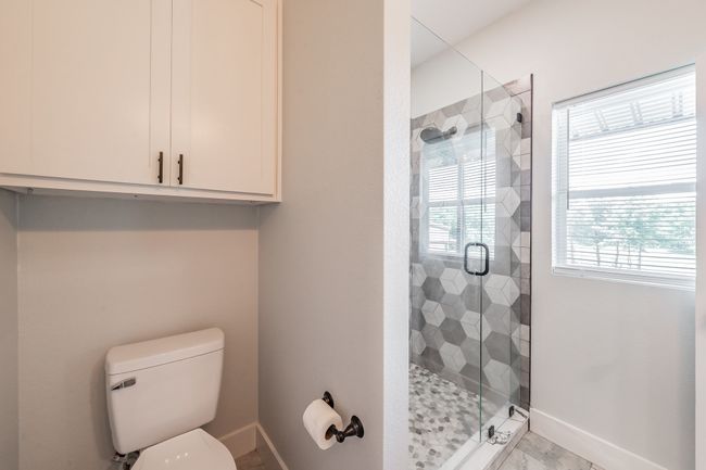 Bathroom with baseboards, a shower stall, and toilet | Image 33
